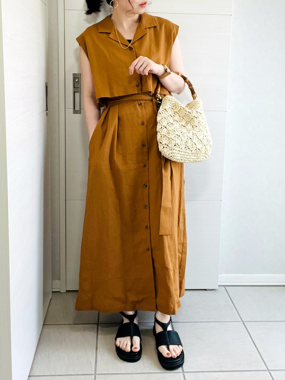 ブラウン系のワンピース、ブラック系のサンダル、ベージュ系のショルダーバッグを着用したレディースの夏コーディネートの3枚目の写真