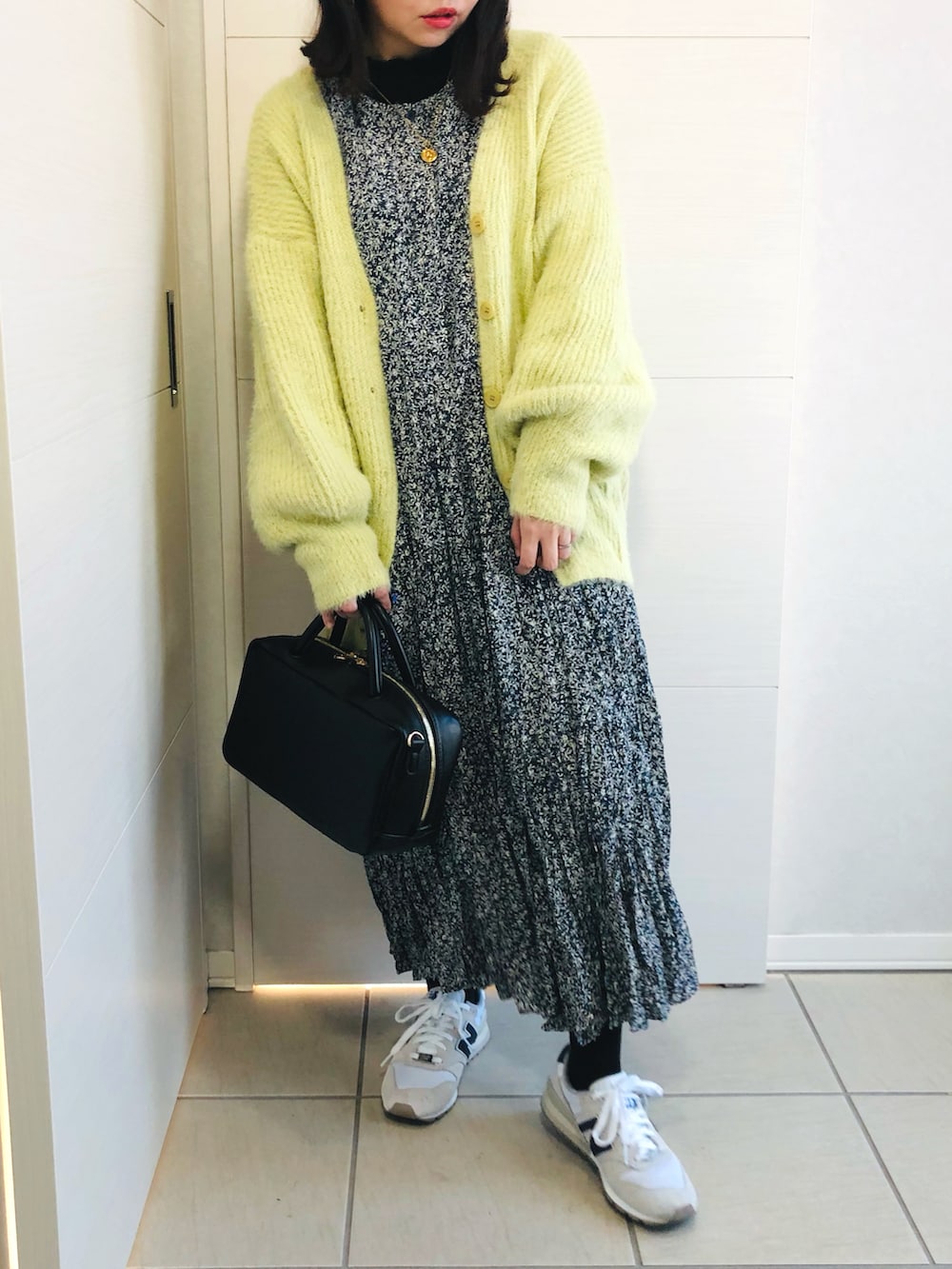 グリーン系のカーディガン/ボレロ、ブルー系のワンピース、ホワイト系のスニーカーを着用したレディースの冬コーディネートの2枚目の写真