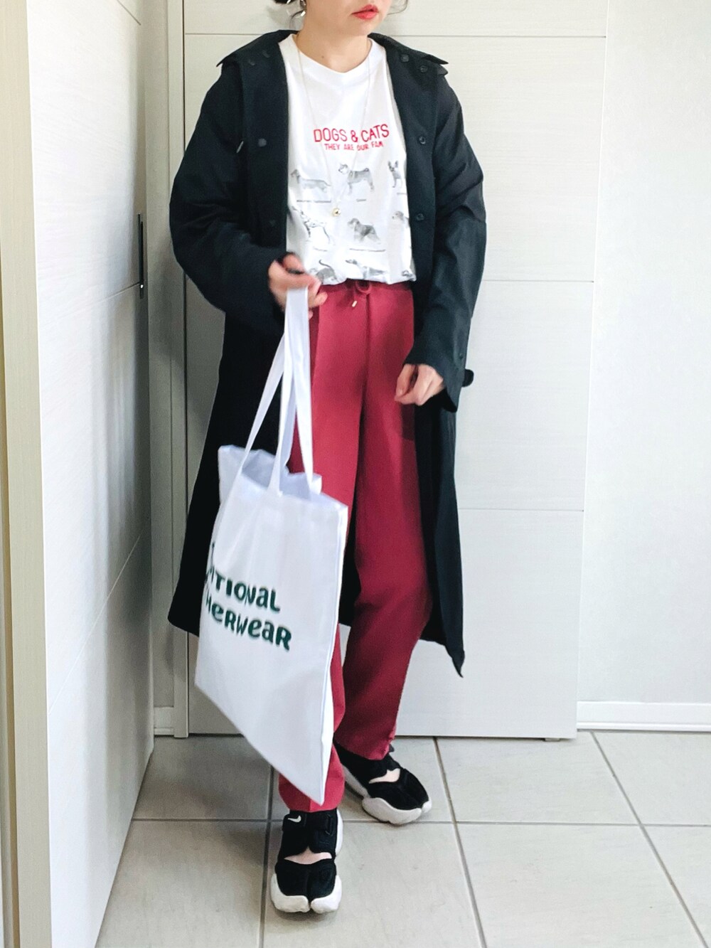 ホワイト系のTシャツ/カットソー、レッド系のスラックス、ブラック系のスニーカーを着用したレディースの春コーディネートの2枚目の写真