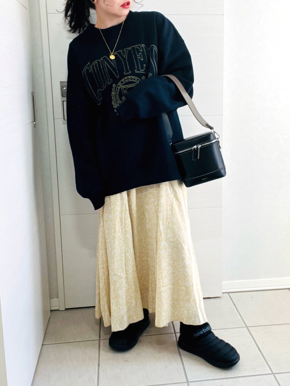 ブルー系のスウェット、イエロー系のスカート、ブラック系のスニーカーを着用したレディースの冬コーディネートの3枚目の写真