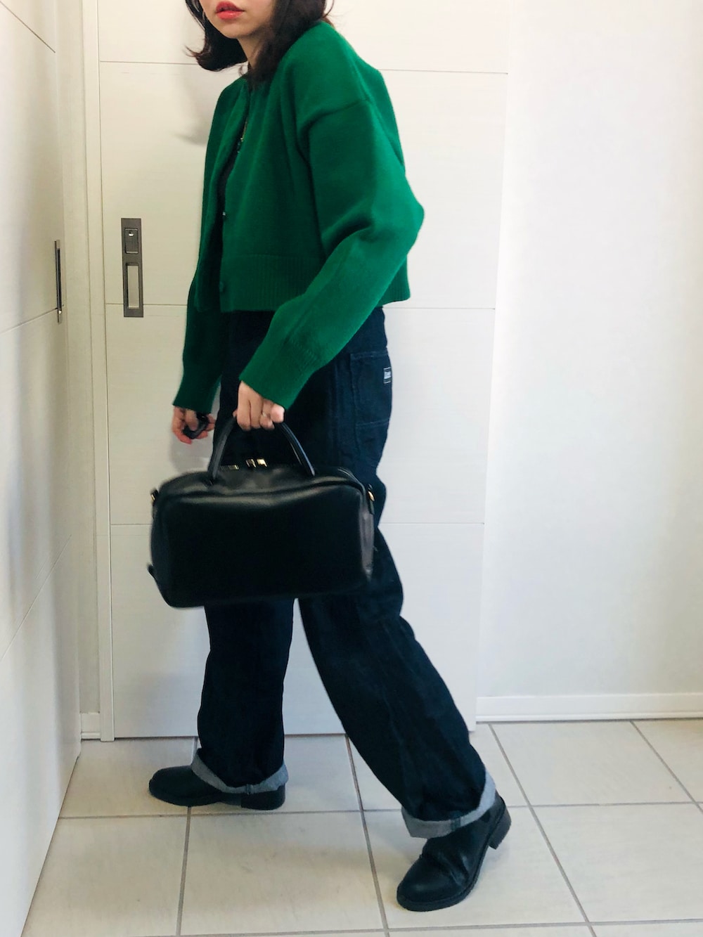 グリーン系のカーディガン/ボレロ、ブルー系のセットアップ、ブラック系のブーツを着用したレディースの冬コーディネートの2枚目の写真