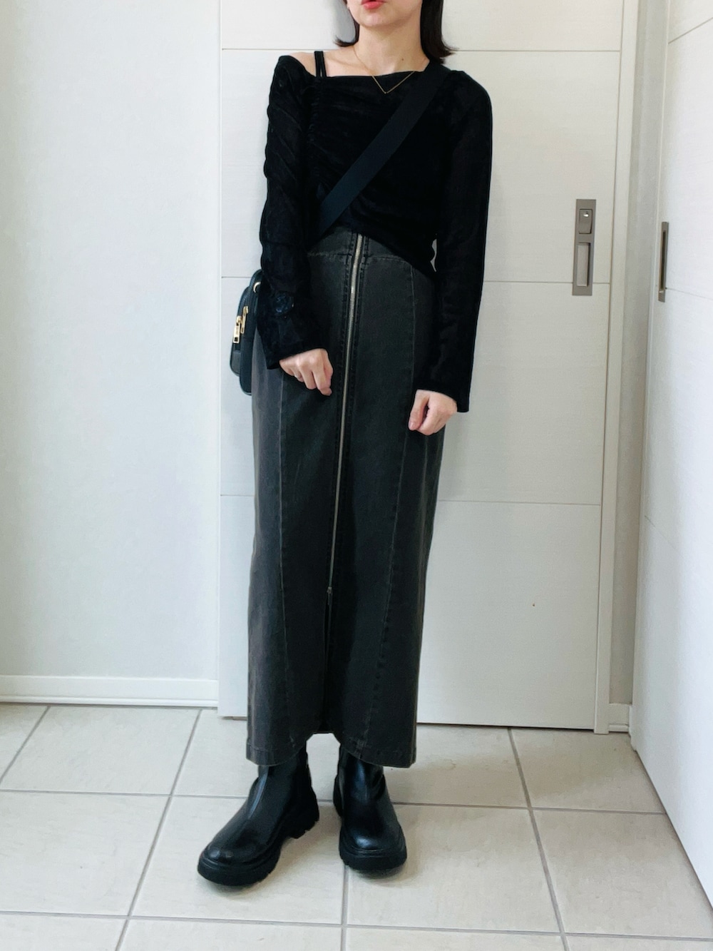 ブラック系のTシャツ/カットソー、ブラック系のブーツ、ブラック系のスカートを着用したレディースの秋コーディネートの4枚目の写真