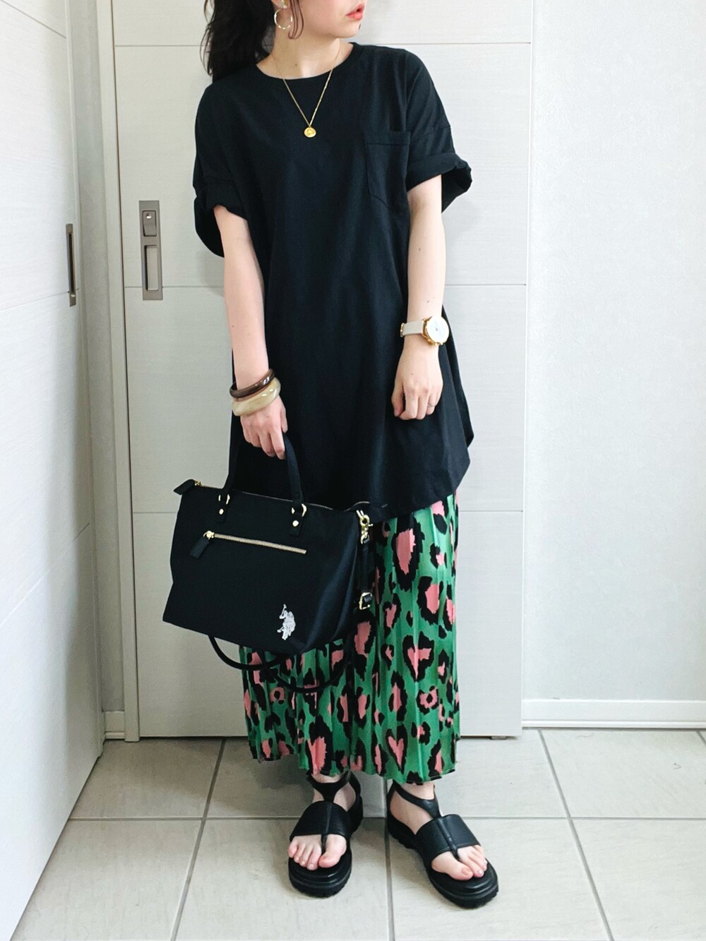 ブラック系のTシャツ/カットソー、グリーン系のスカート、ブラック系のサンダルを着用したレディースの夏コーディネートの2枚目の写真
