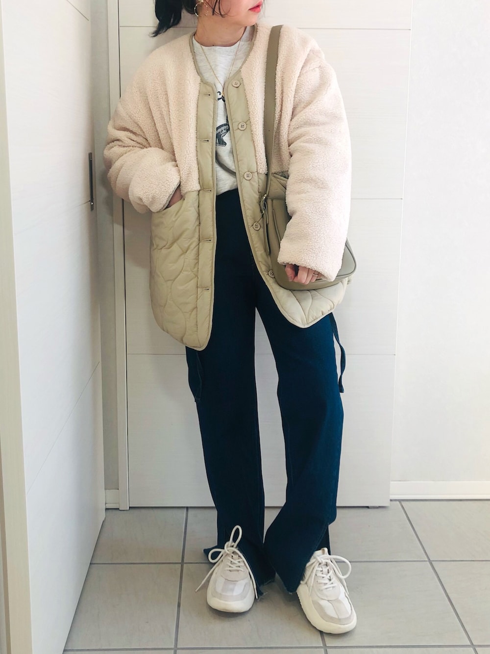ホワイト系のその他アウター、ベージュ系のスウェット、ブルー系のデニムパンツを着用したレディースの冬コーディネートの2枚目の写真