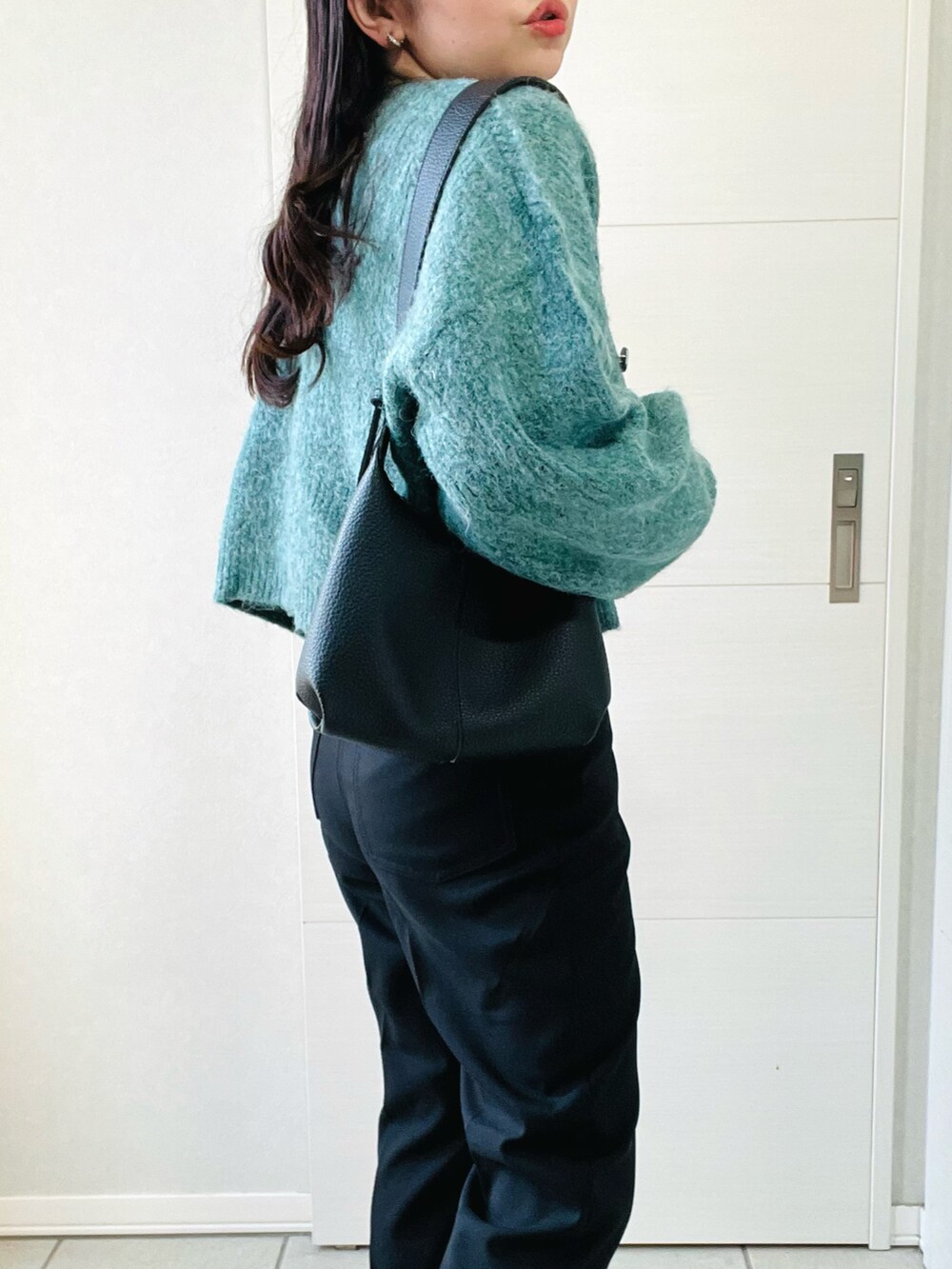 グリーン系のカーディガン/ボレロ、ブラック系のTシャツ/カットソー、ブラック系のスラックスを着用したレディースの秋コーディネートの3枚目の写真