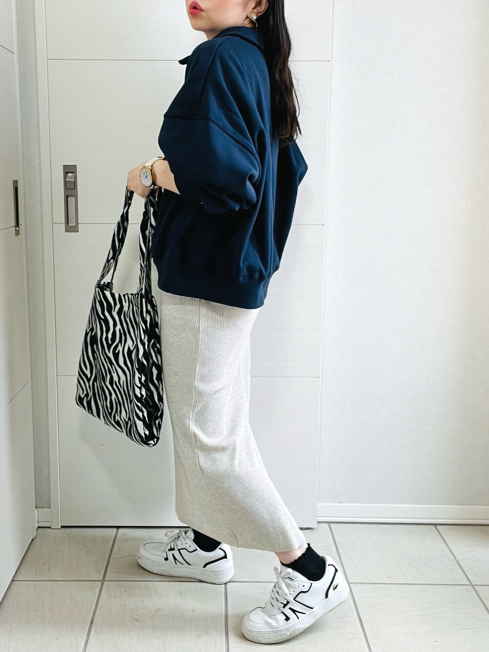 ブルー系のスウェット、ベージュ系のスカート、ホワイト系のスニーカーを着用したレディースの秋コーディネートの5枚目の写真