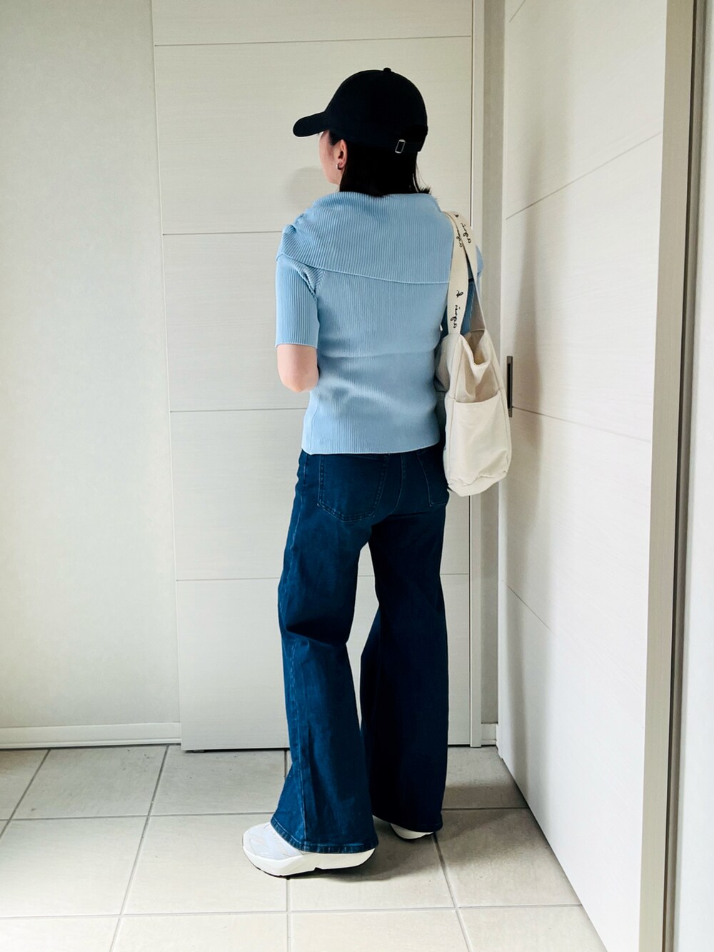 ホワイト系のスニーカー、ブルー系のニット/セーター、ベージュ系のトートバッグを着用したレディースの夏コーディネートの4枚目の写真