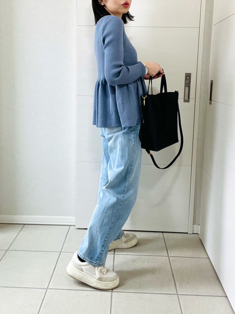 グレー系のカーディガン/ボレロ、ブルー系のデニムパンツ、ホワイト系のスニーカーを着用したレディースの春コーディネートの4枚目の写真