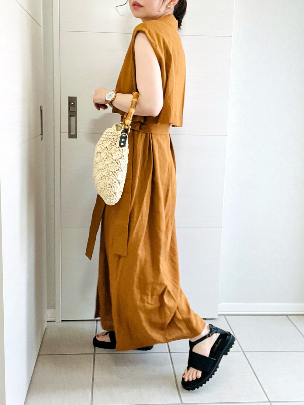 ブラウン系のワンピース、ブラック系のサンダル、ベージュ系のショルダーバッグを着用したレディースの夏コーディネートの4枚目の写真
