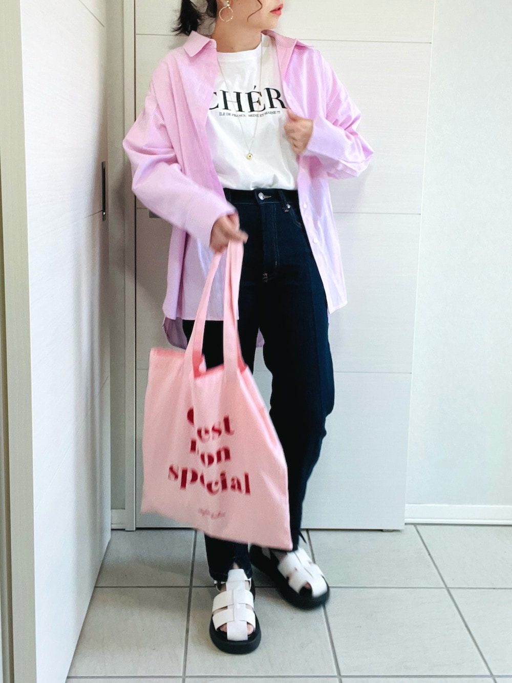 ピンク系のシャツ/ブラウス、ホワイト系のTシャツ/カットソー、ブルー系のデニムパンツを着用したレディースの春コーディネートの5枚目の写真