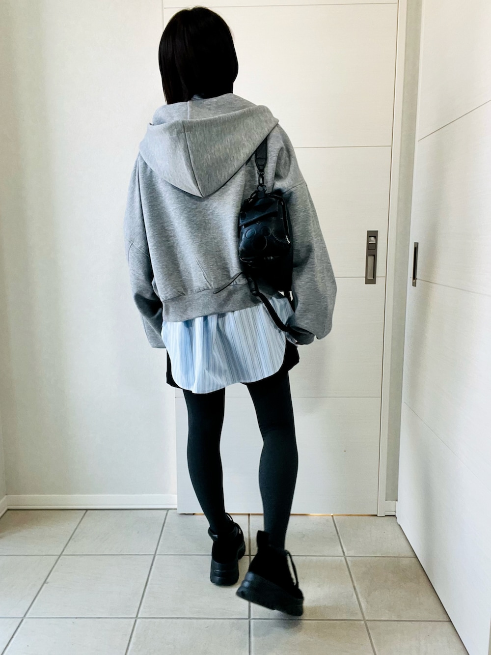 グレー系のパーカー、ブルー系のシャツ/ブラウス、ブラック系のその他パンツを着用したレディースの春コーディネートの3枚目の写真