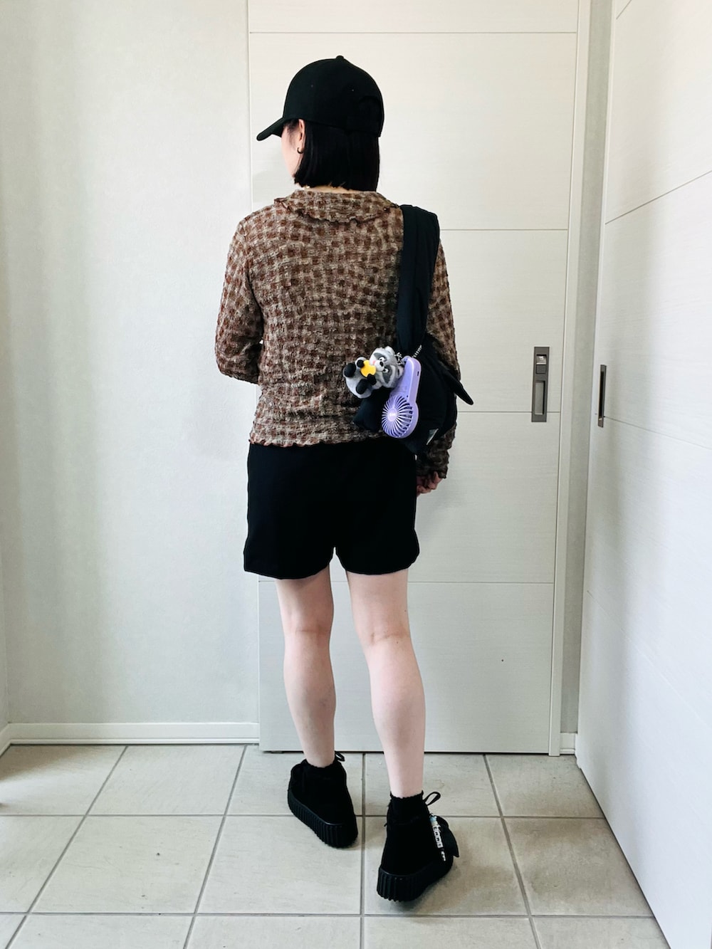 ブラウン系のカーディガン/ボレロ、ブラック系のトートバッグ、ブラック系のブーツを着用したレディースの夏コーディネートの4枚目の写真