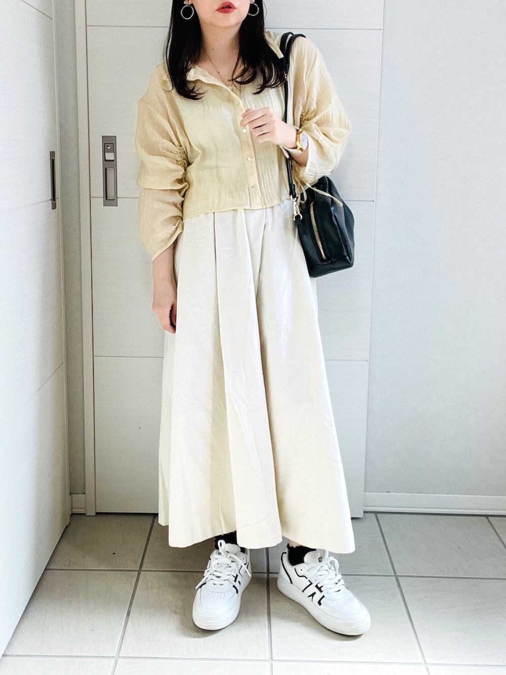 イエロー系のシャツ/ブラウス、ホワイト系のデニムスカート、ホワイト系のスニーカーを着用したレディースの夏コーディネートの3枚目の写真