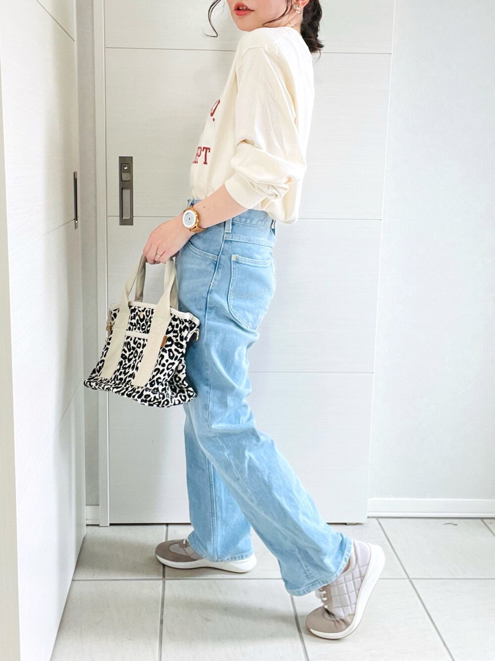 ベージュ系のTシャツ/カットソー、ブルー系のデニムパンツ、ベージュ系のスニーカーを着用したレディースの夏コーディネートの5枚目の写真