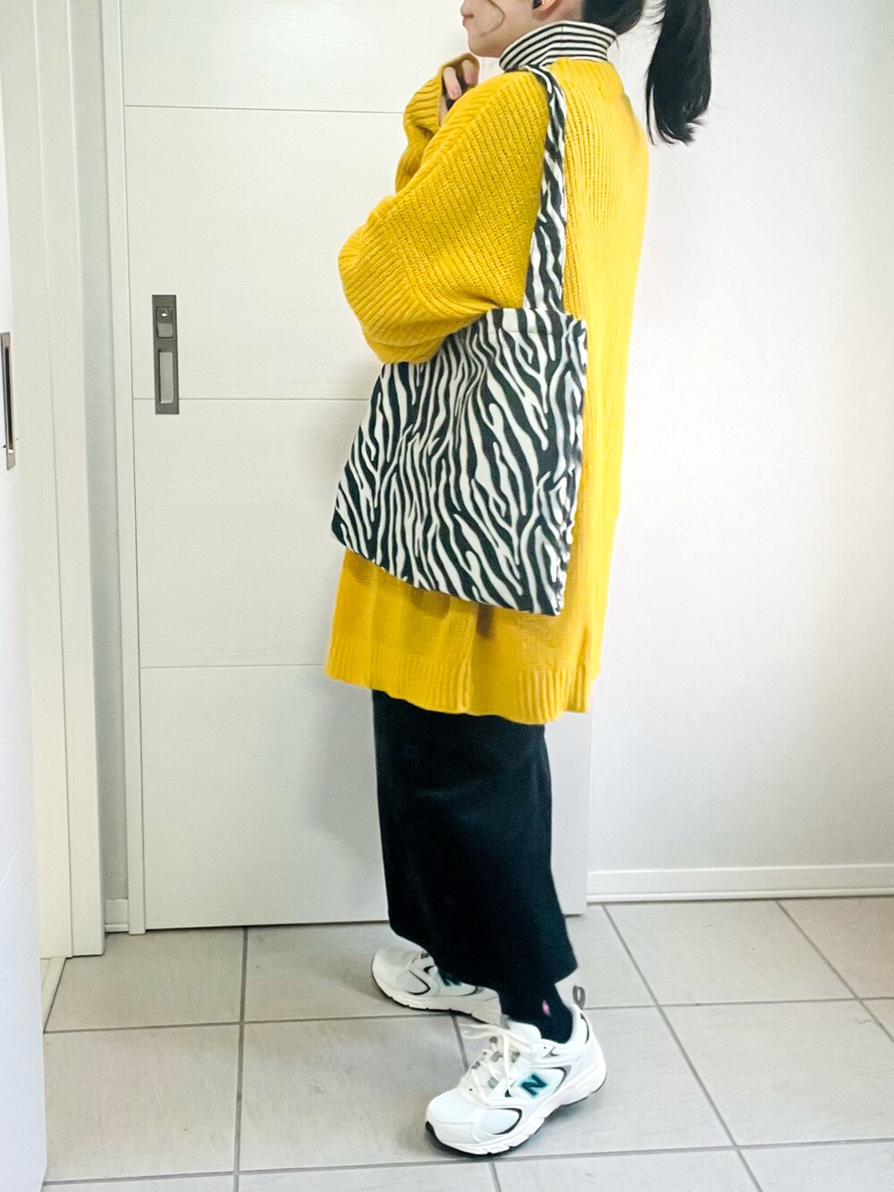 イエロー系のカーディガン/ボレロ、その他のニット/セーター、ブラック系のジャンパースカートを着用したレディースの冬コーディネートの4枚目の写真