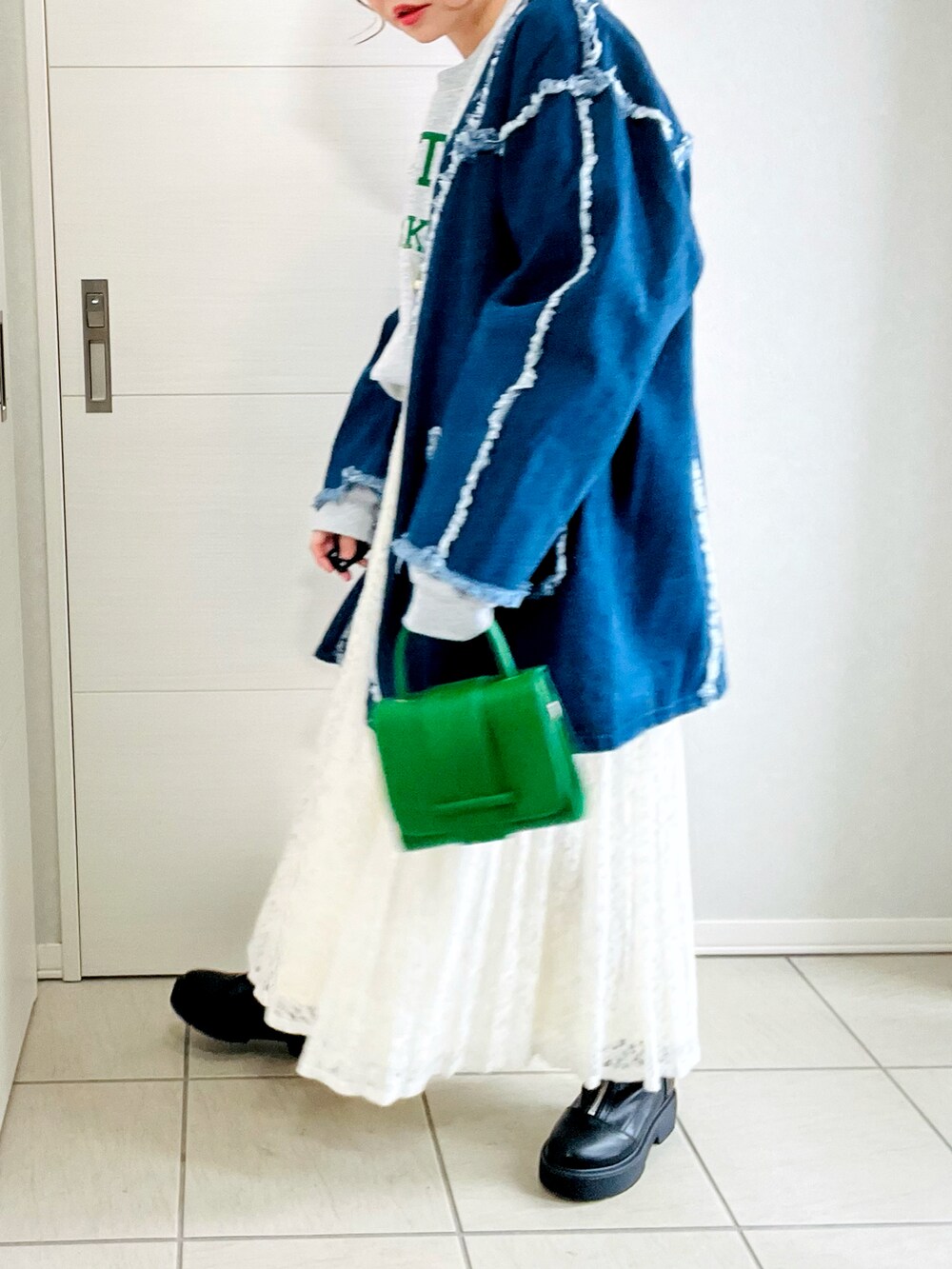 ブルー系のデニムジャケット、グレー系のスウェット、ホワイト系のスカートを着用したレディースの冬コーディネートの3枚目の写真