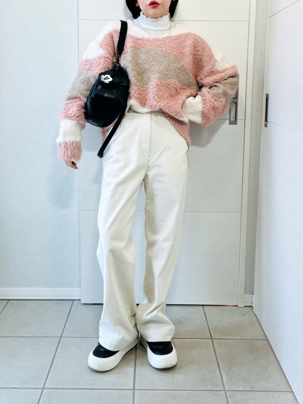 ホワイト系のニット/セーター、ホワイト系のその他パンツ、ブラック系のハンドバッグを着用したレディースの秋コーディネートの4枚目の写真