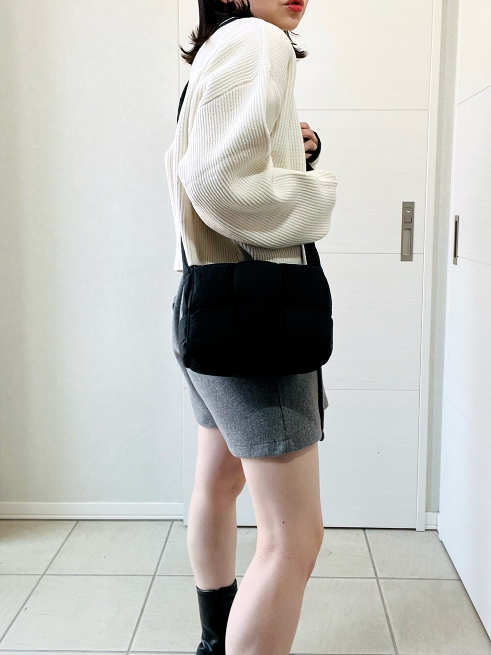 ホワイト系のニット/セーター、ブラック系のブーツ、グレー系のその他パンツを着用したレディースの秋コーディネートの3枚目の写真