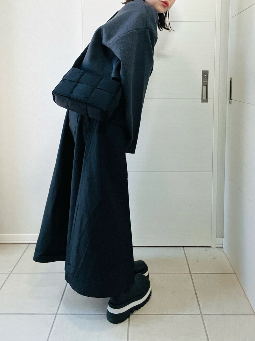 ブラック系のワンピース、ブラック系のショルダーバッグ、ブラック系のブーツを着用したレディースの秋コーディネートの4枚目の写真