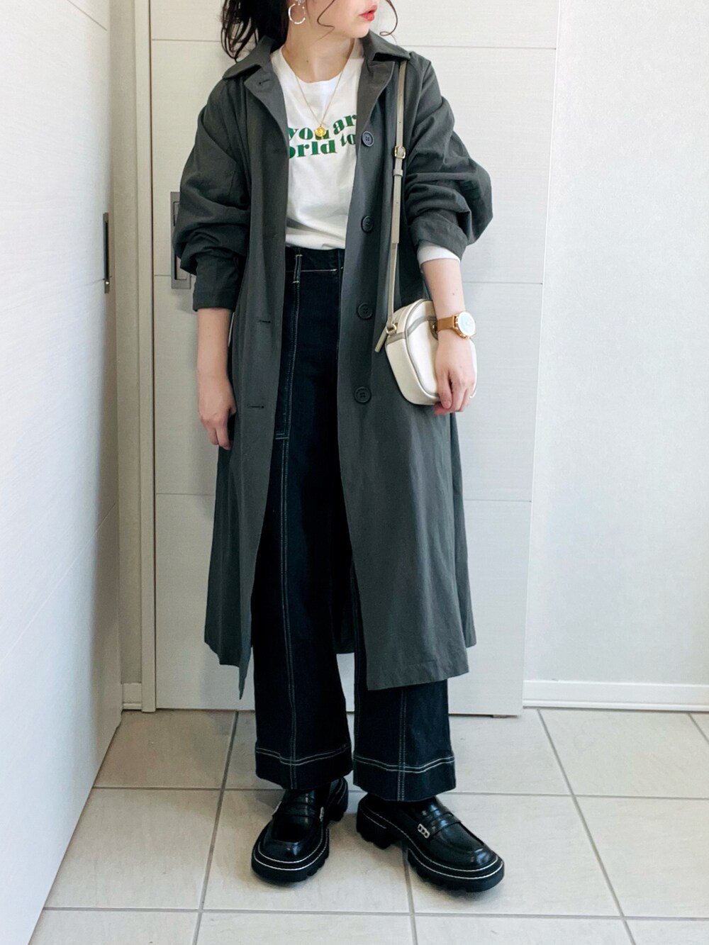 グリーン系のステンカラーコート、ホワイト系のTシャツ/カットソー、ブラック系のデニムパンツを着用したレディースの春コーディネートの4枚目の写真