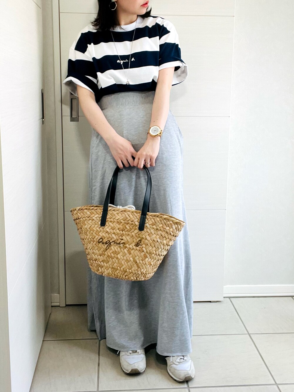 ブルー系のTシャツ/カットソー、グレー系のスカート、ブラック系のかごバッグを着用したレディースの夏コーディネートの2枚目の写真