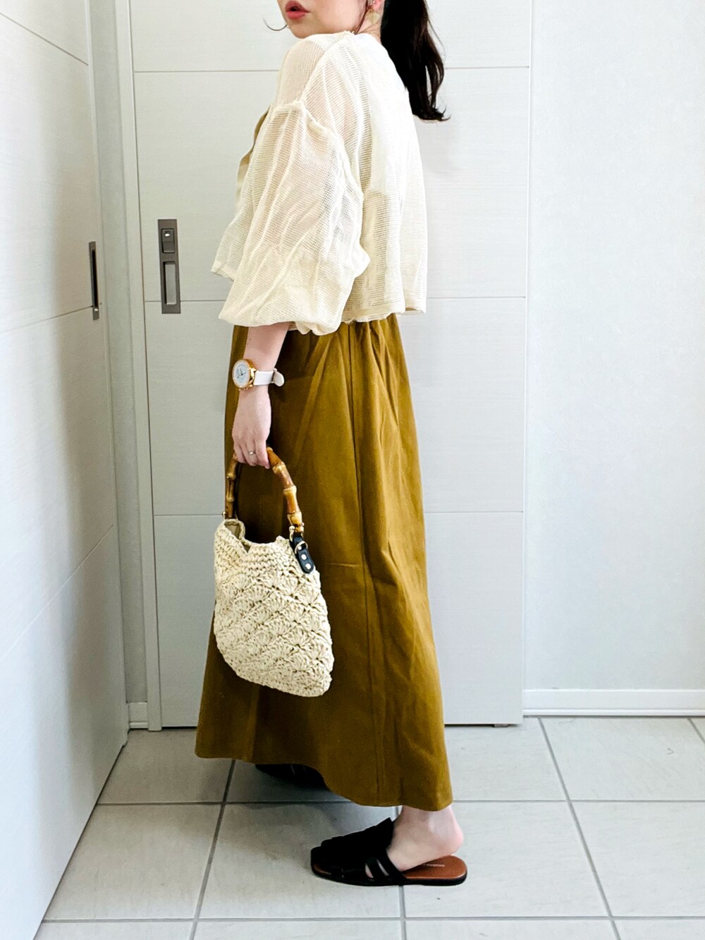 ホワイト系のカーディガン/ボレロ、イエロー系のワンピース、ブラック系のサンダルを着用したレディースの夏コーディネートの5枚目の写真