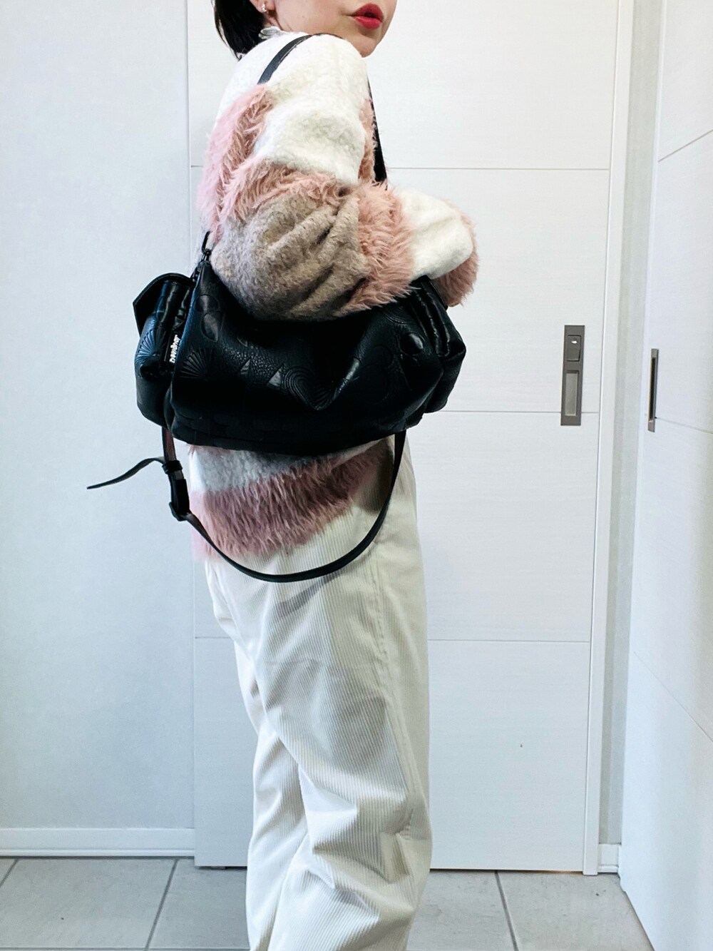 ホワイト系のニット/セーター、ホワイト系のその他パンツ、ブラック系のハンドバッグを着用したレディースの秋コーディネートの3枚目の写真