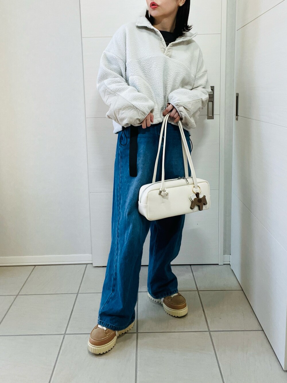 ホワイト系のTシャツ/カットソー、ブルー系のデニムパンツ、ブラウン系のブーツを着用したレディースの冬コーディネートの2枚目の写真