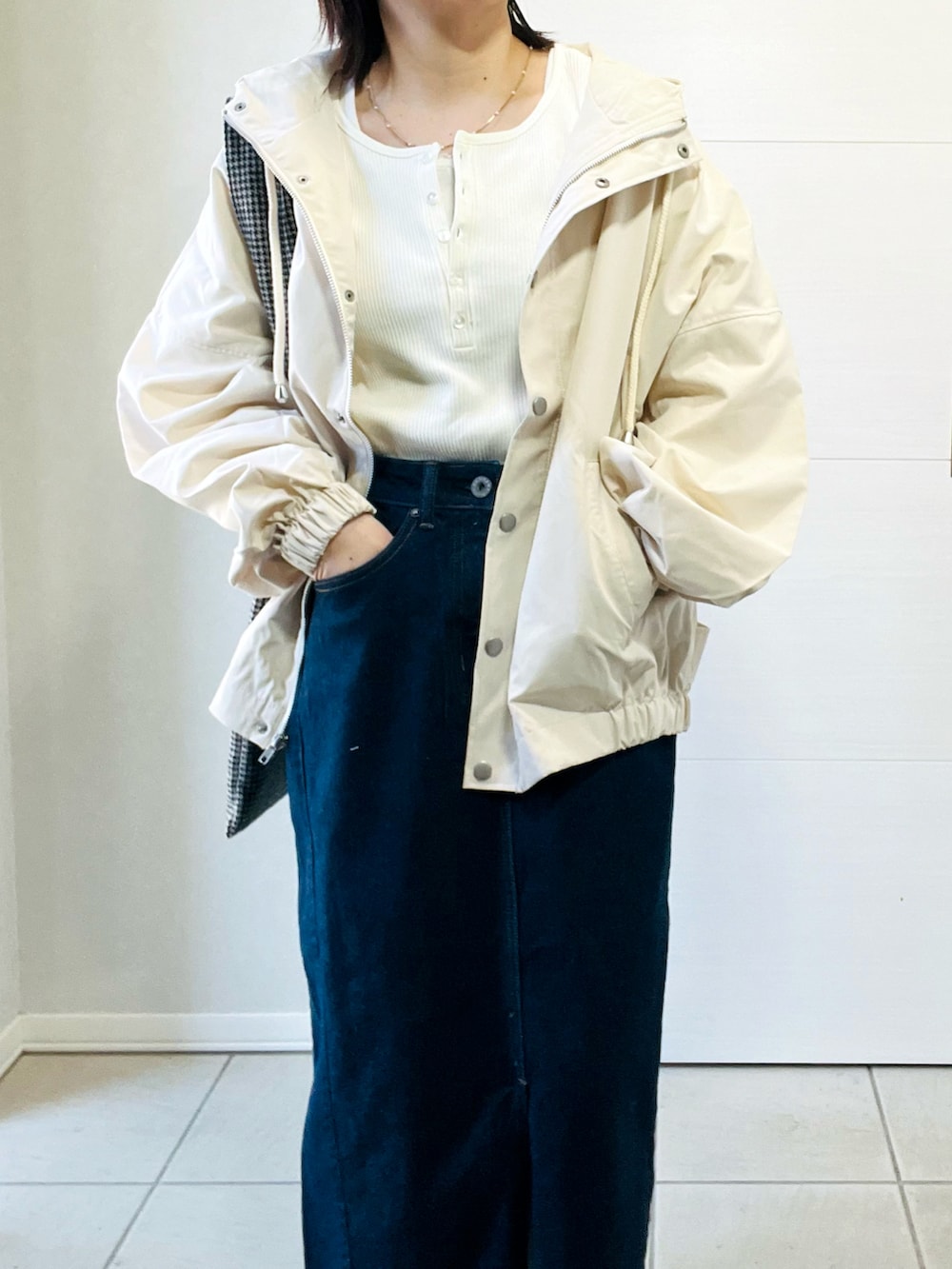 ホワイト系のマウンテンパーカー、グレー系のスニーカー、ホワイト系のTシャツ/カットソーを着用したレディースの春コーディネートの2枚目の写真