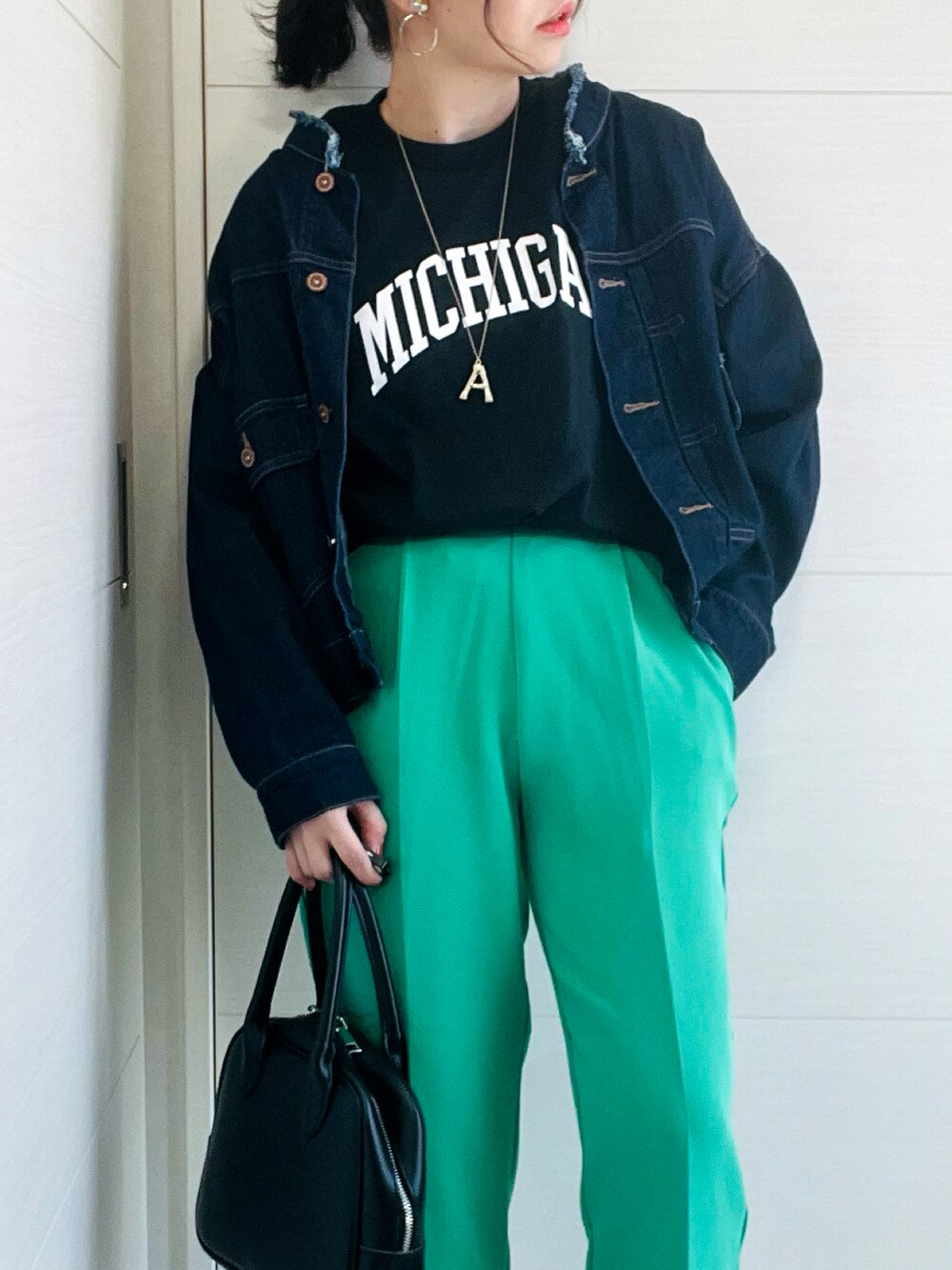 ブラック系のTシャツ/カットソー、ブルー系のデニムジャケット、グリーン系のスラックスを着用したレディースの春コーディネートの3枚目の写真