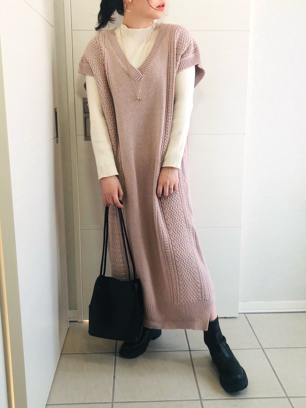 パープル系のワンピース、ブラック系のブーツ、ブラック系のショルダーバッグを着用したレディースの冬コーディネートの3枚目の写真