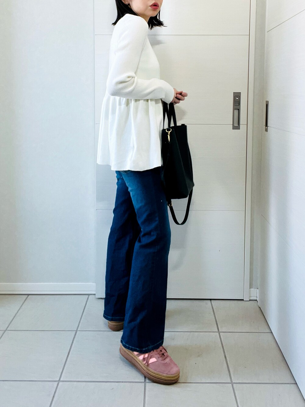 ホワイト系のニット/セーター、ブルー系のデニムパンツ、レッド系のスニーカーを着用したレディースの春コーディネートの5枚目の写真
