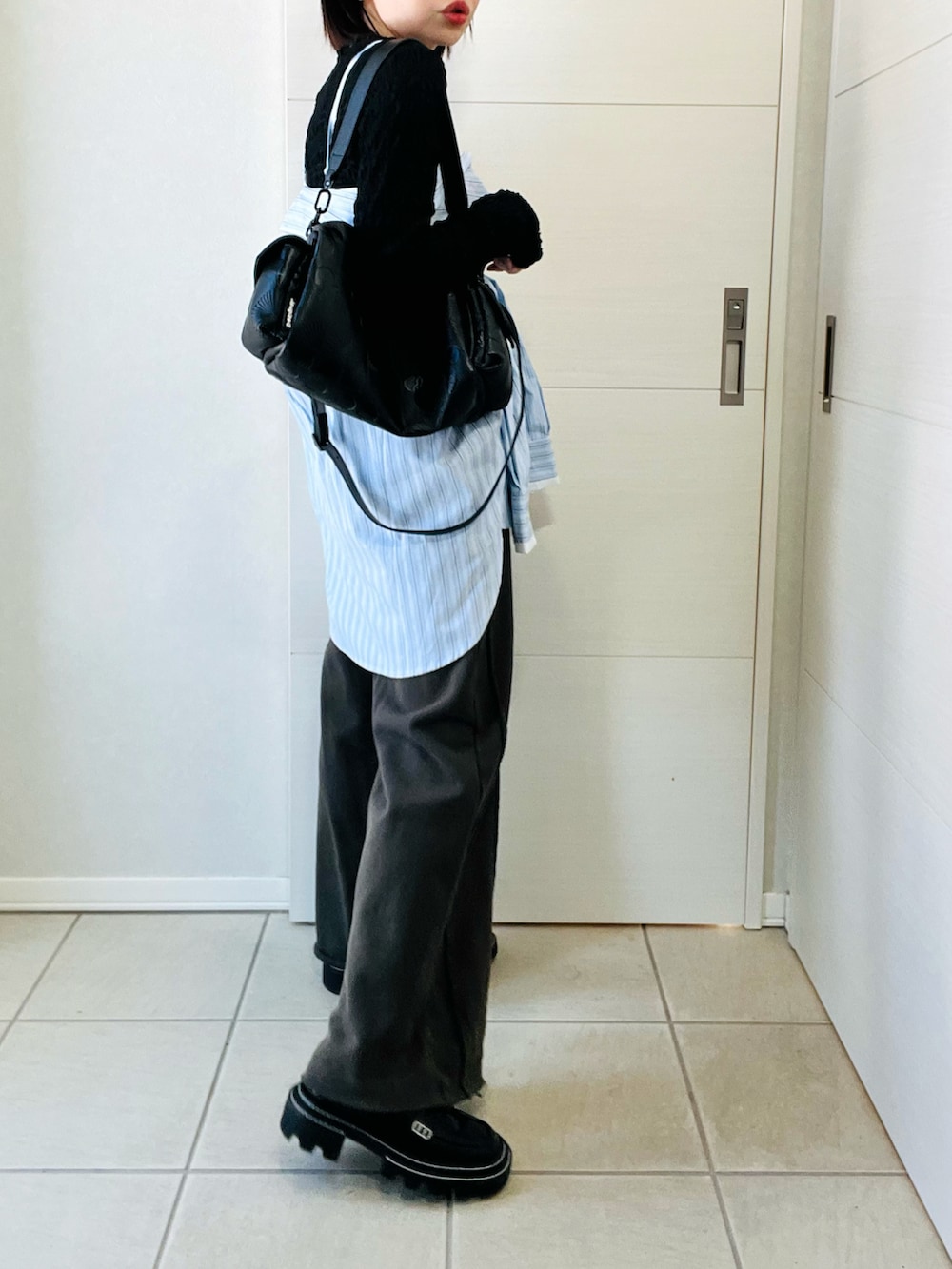 ブルー系のシャツ/ブラウス、ブラック系のスウェットパンツ、ブラック系のハンドバッグを着用したレディースの冬コーディネートの5枚目の写真