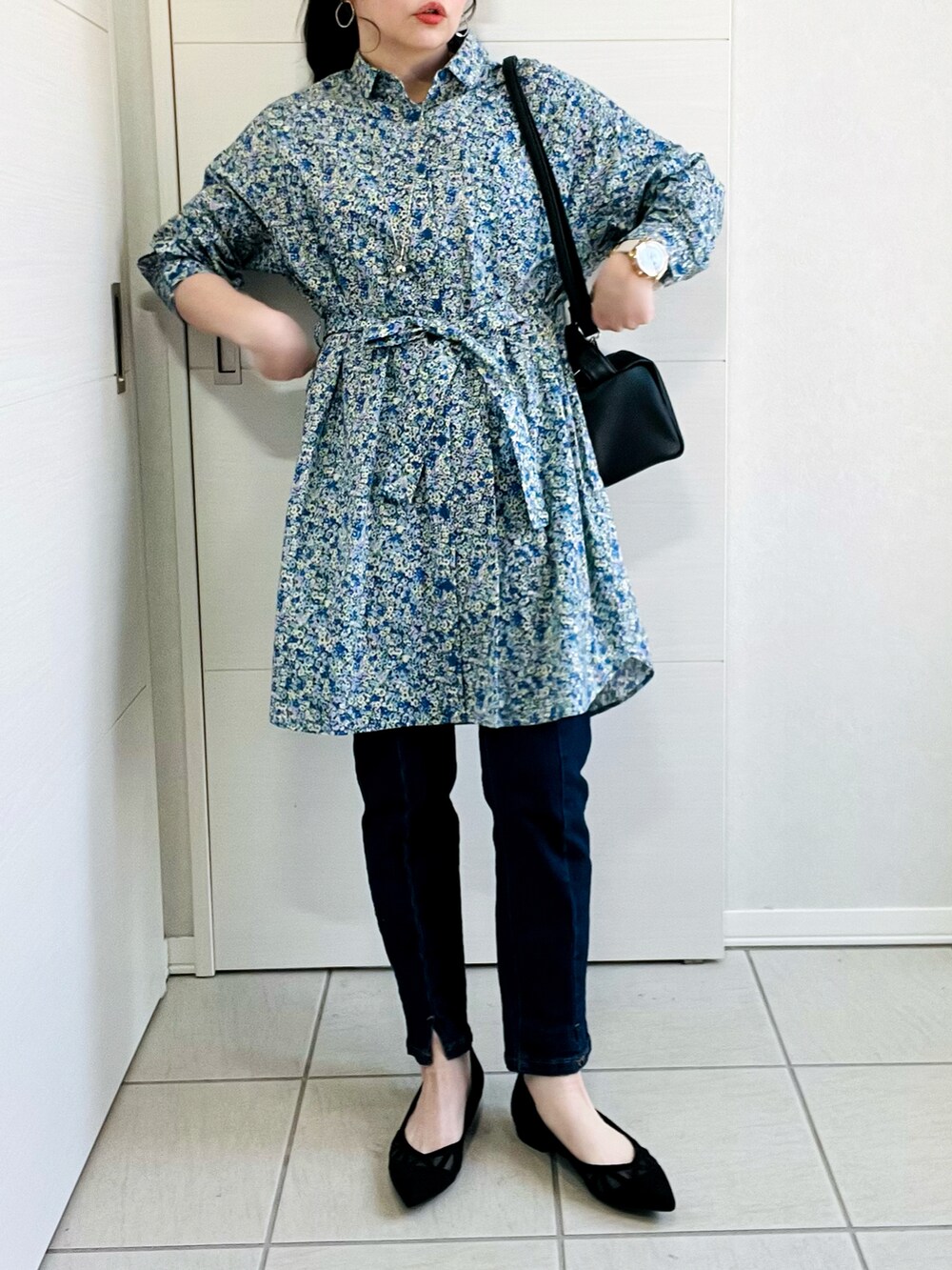 ブルー系のシャツワンピース、ブルー系のデニムパンツ、ブラック系のパンプスを着用したレディースの春コーディネートの2枚目の写真