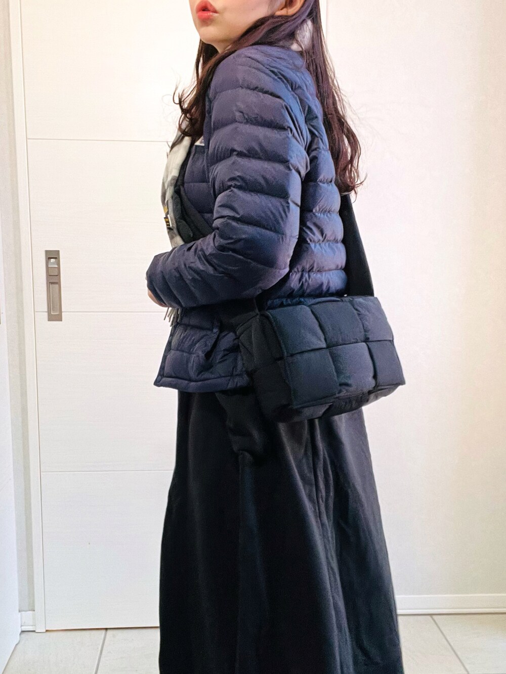 ブルー系のダウンジャケット/コート、ブラック系のワンピース、ベージュ系のスリッポンを着用したレディースの冬コーディネートの3枚目の写真