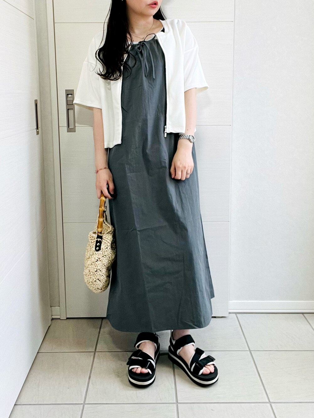 グレー系のワンピース、ブラック系のサンダル、ベージュ系のショルダーバッグを着用したレディースの夏コーディネートの4枚目の写真