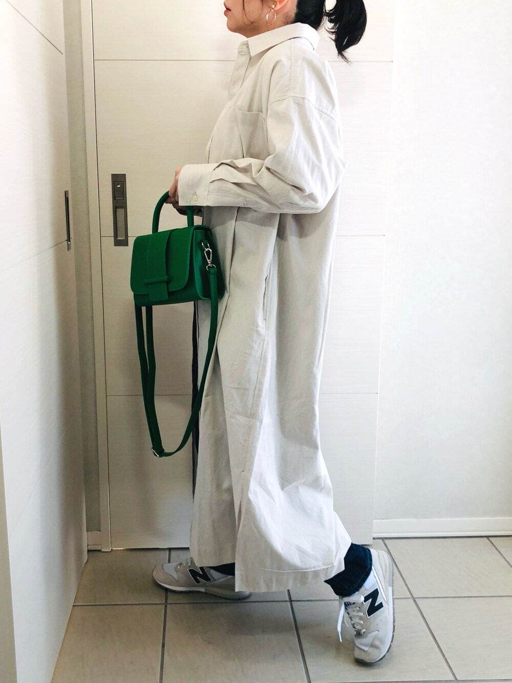 ベージュ系のワンピース、ホワイト系のTシャツ/カットソー、ブルー系のデニムパンツを着用したレディースの冬コーディネートの4枚目の写真