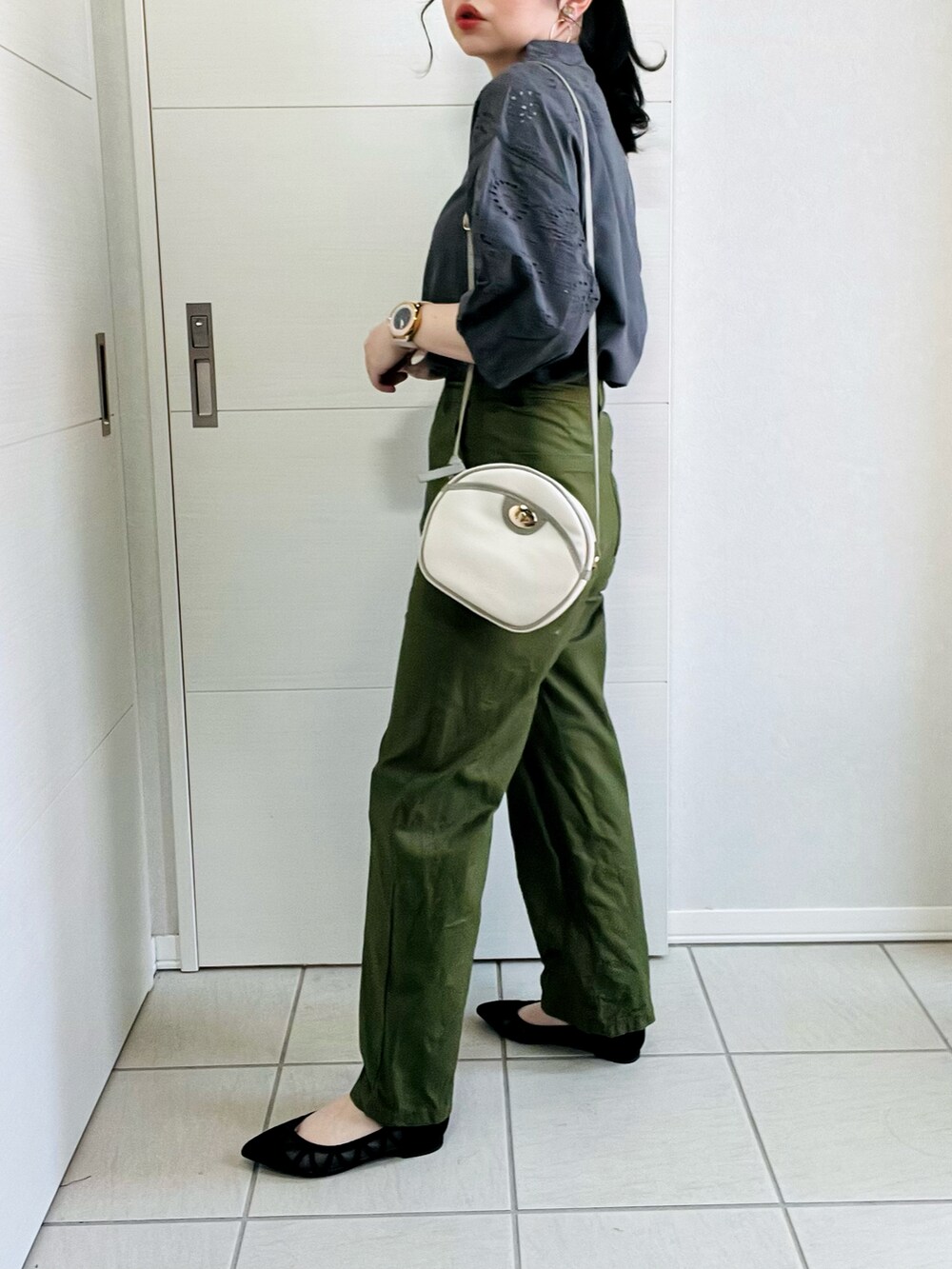 グレー系のシャツ/ブラウス、ブラック系のパンプス、ホワイト系のショルダーバッグを着用したレディースの春コーディネートの5枚目の写真