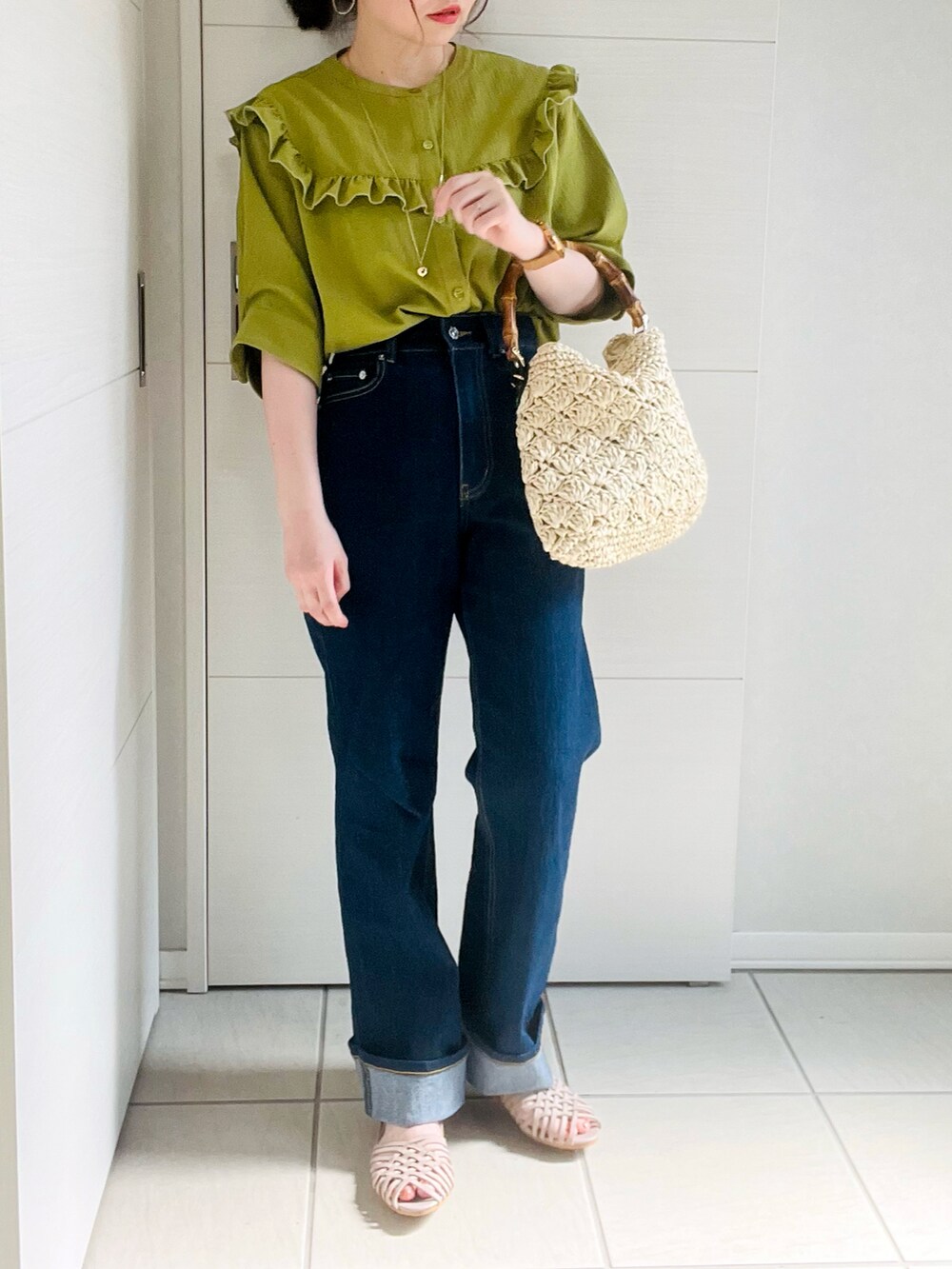 グリーン系のシャツ/ブラウス、ブルー系のデニムパンツ、グレー系のサンダルを着用したレディースの夏コーディネートの3枚目の写真