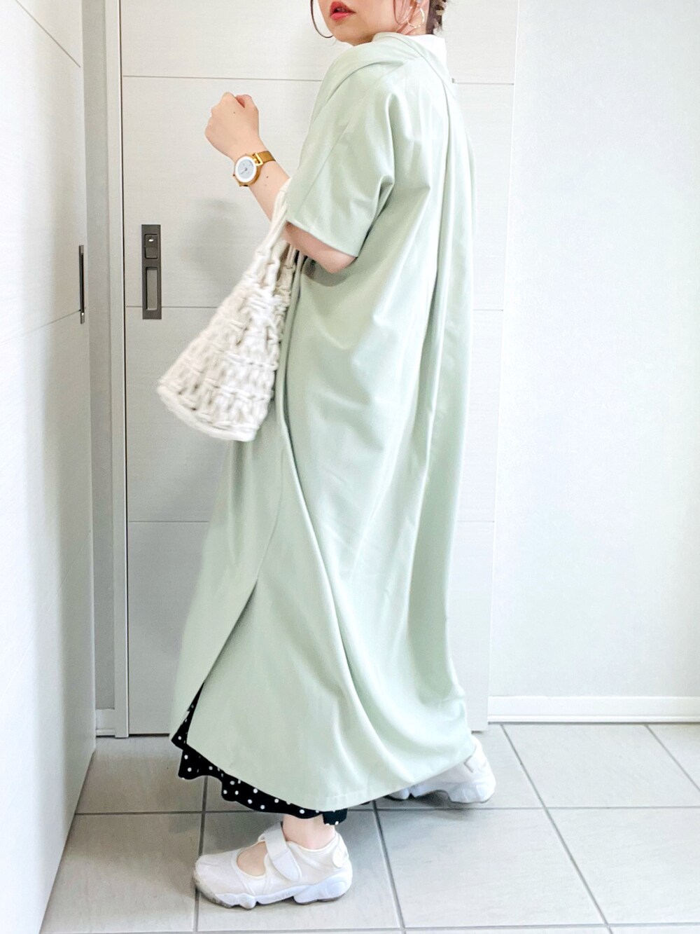 ホワイト系のTシャツ/カットソー、グリーン系のワンピース、ブラック系のスカートを着用したレディースの春コーディネートの4枚目の写真