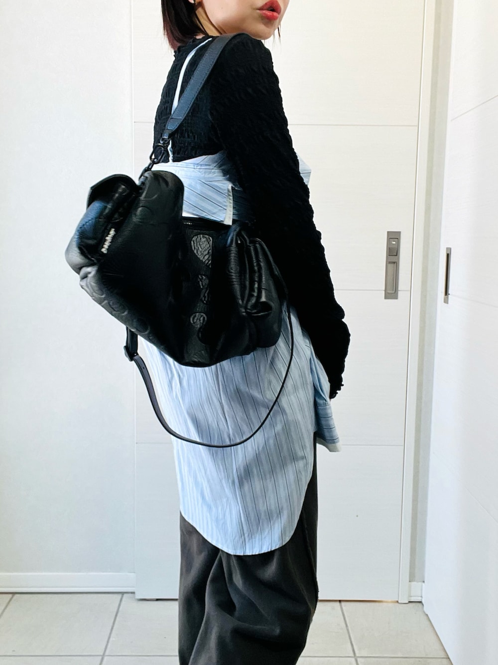 ブルー系のシャツ/ブラウス、ブラック系のスウェットパンツ、ブラック系のハンドバッグを着用したレディースの冬コーディネートの2枚目の写真