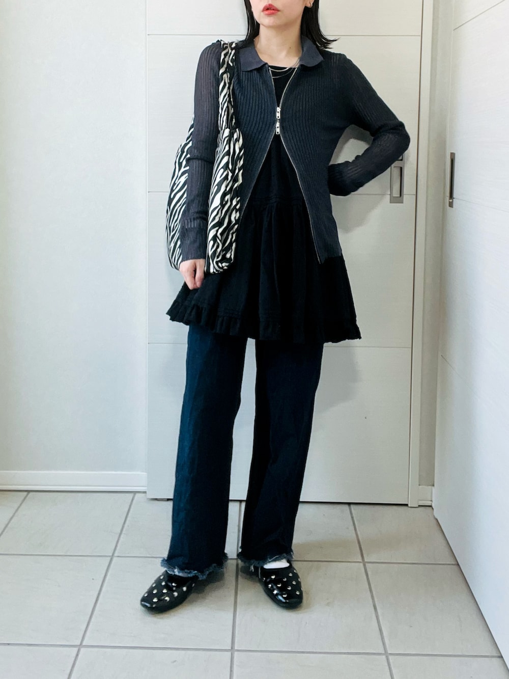 グレー系のカーディガン/ボレロ、ブラック系のワンピース、ブルー系のデニムパンツを着用したレディースの春コーディネートの4枚目の写真