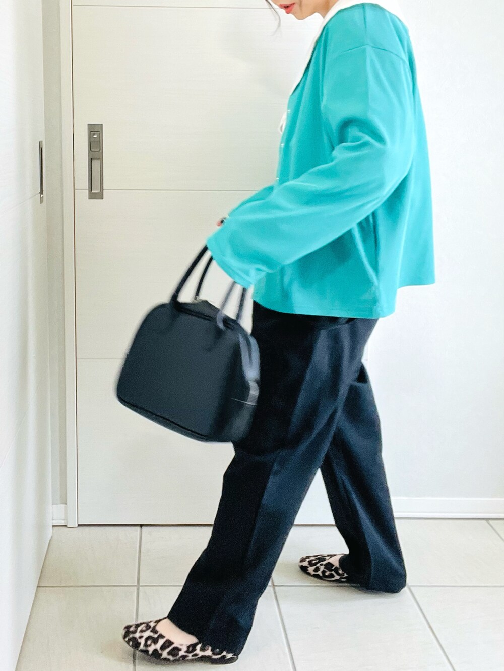 グリーン系のカーディガン/ボレロ、ホワイト系のシャツ/ブラウス、ブラック系のその他パンツを着用したレディースの春コーディネートの5枚目の写真