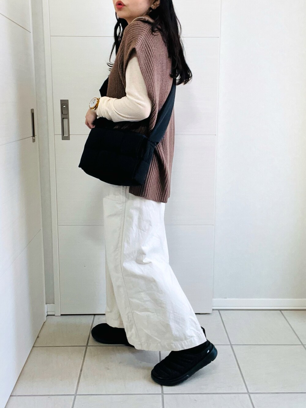 ブラウン系のベスト、ホワイト系のTシャツ/カットソー、ホワイト系のスカートを着用したレディースの秋コーディネートの5枚目の写真