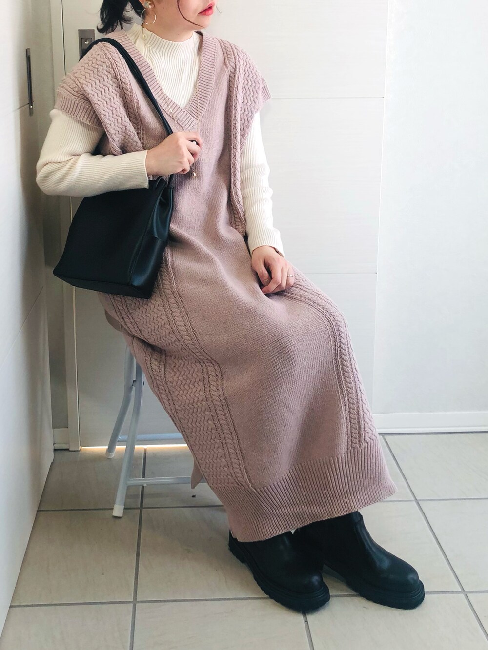 パープル系のワンピース、ブラック系のブーツ、ブラック系のショルダーバッグを着用したレディースの冬コーディネートの4枚目の写真