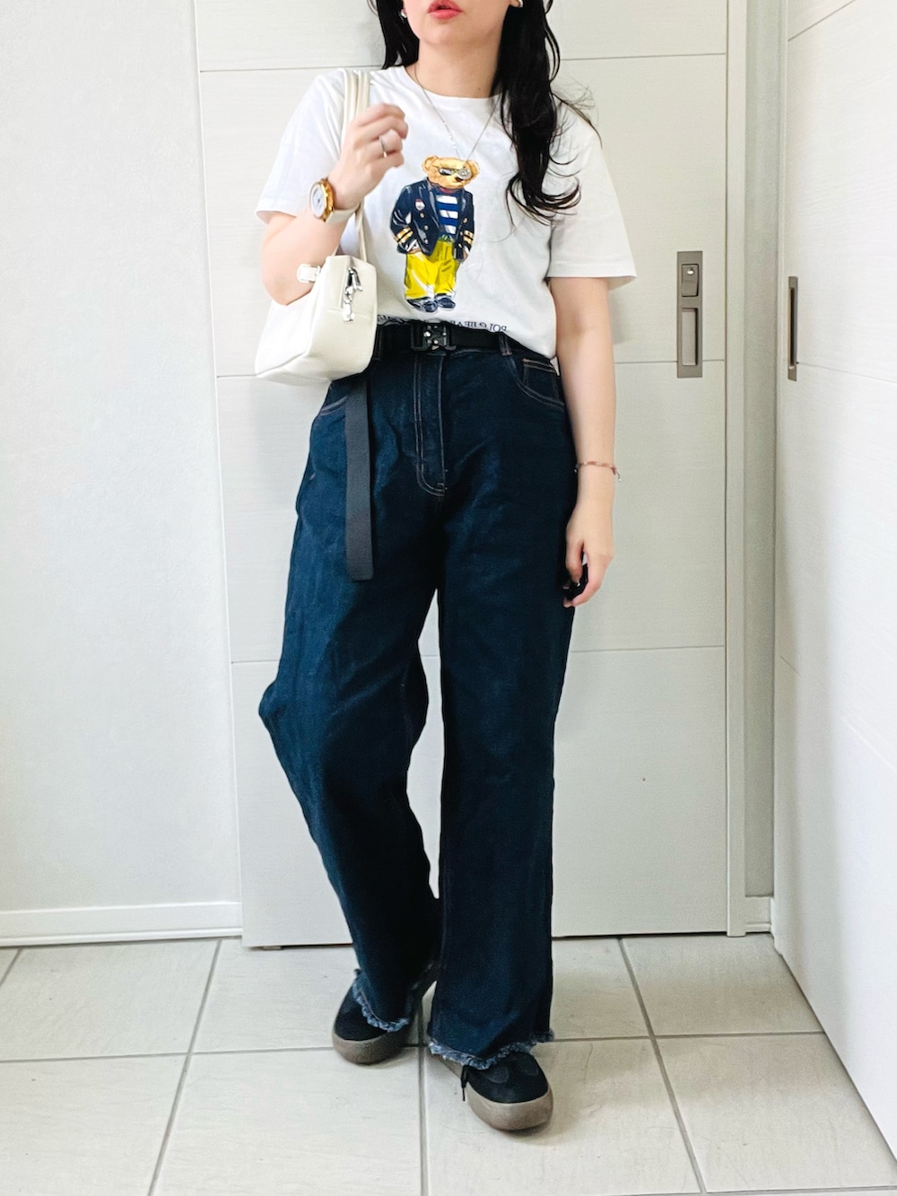 ホワイト系のTシャツ/カットソー、ブルー系のデニムパンツ、ブラック系のスニーカーを着用したレディースの夏コーディネートの4枚目の写真