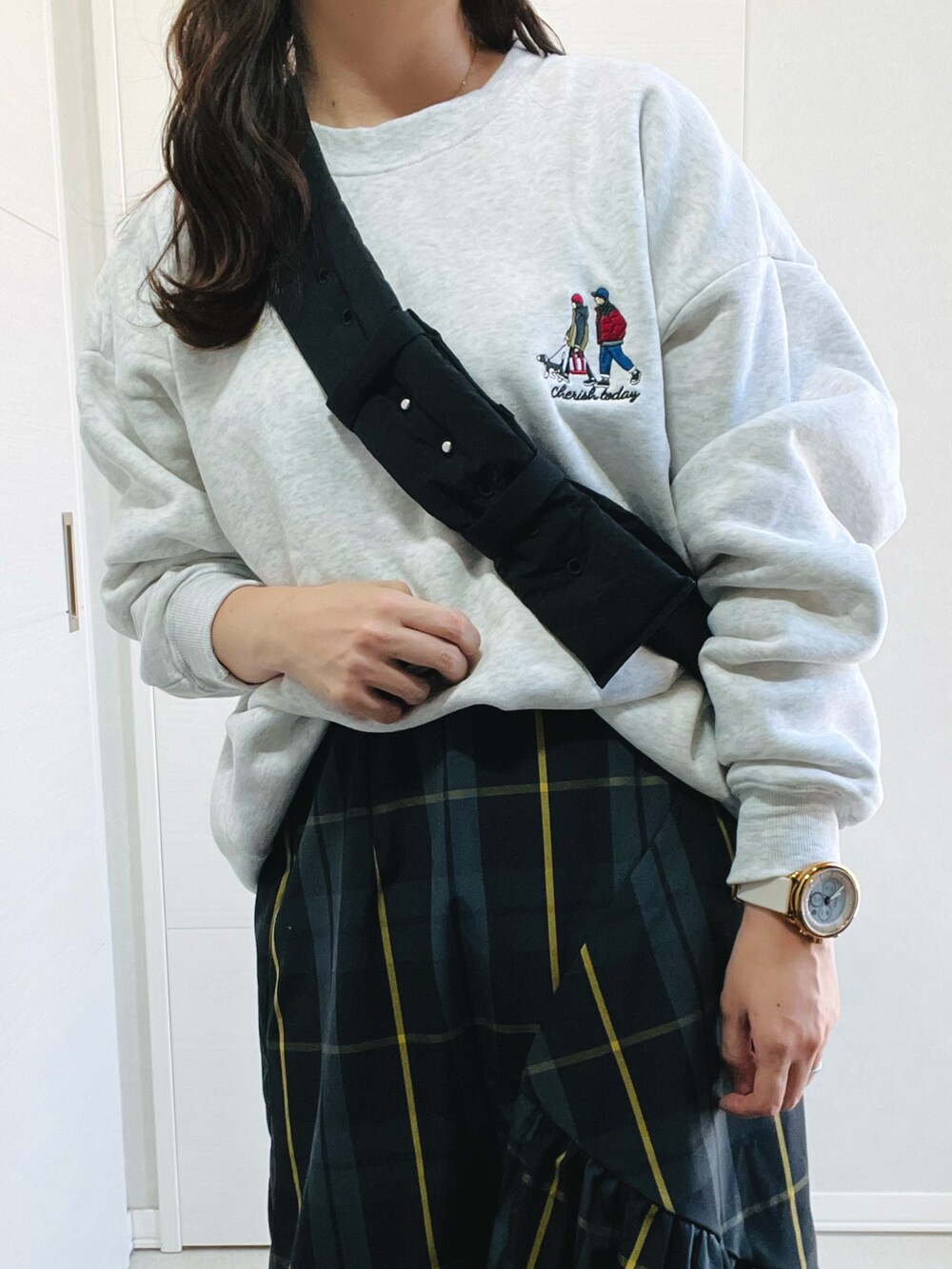 グレー系のスウェット、ブラック系のスカート、ホワイト系のスニーカーを着用したレディースの秋コーディネートの2枚目の写真