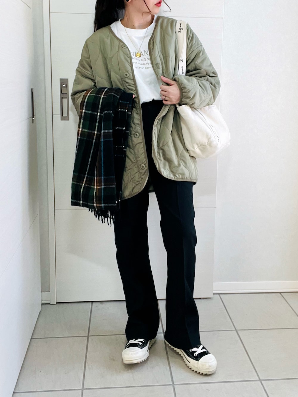 ホワイト系のTシャツ/カットソー、グリーン系のノーカラージャケット、ブラック系のスラックスを着用したレディースの冬コーディネートの2枚目の写真