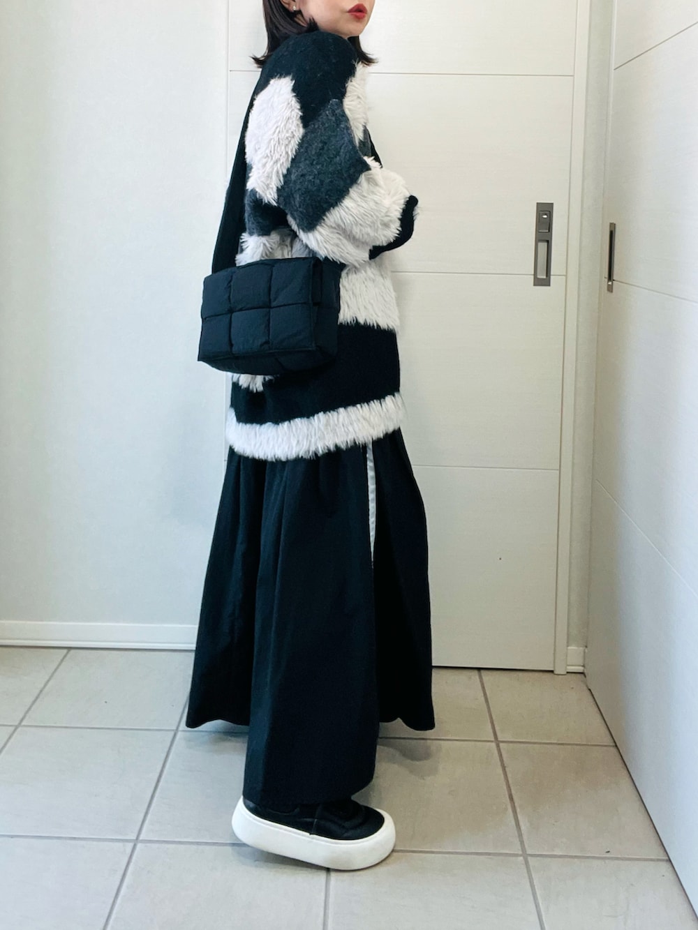 ブラック系のカーディガン/ボレロ、ブラック系のスニーカー、ブラック系のスカートを着用したレディースの秋コーディネートの5枚目の写真