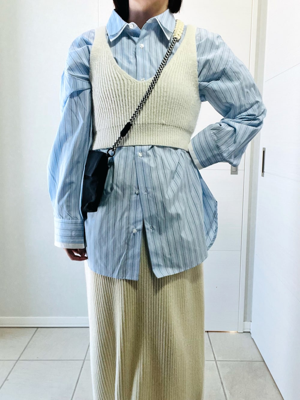 ブルー系のシャツ/ブラウス、ホワイト系のスカート、ブラック系のショルダーバッグを着用したレディースの冬コーディネートの2枚目の写真